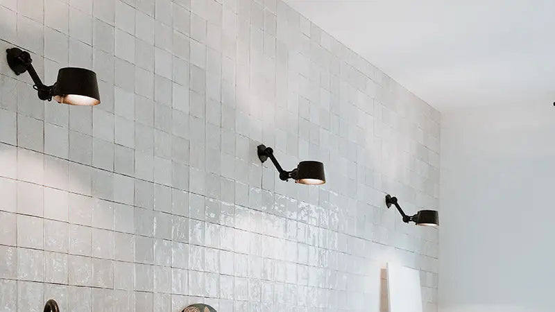 Betegelde muur met verstelbare wandlampen.